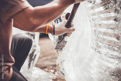 man is carving the ice sculpture for wedding photo