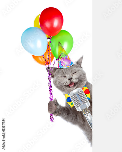 Photography Cat in birthday hat holds retro microphone with balloons