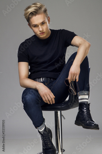 Young male model  sitting on a lader  looking at the camera