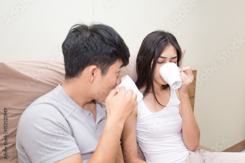 Asian man and woman drinking coffee together.