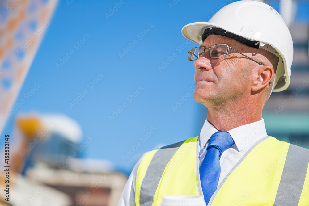Senior foreman in glasses doing his job at building area on sunny day Senior foreman in glasses doing his job at building area on sunny day