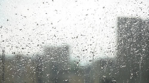 Rainy window overlooking the city on a windy day