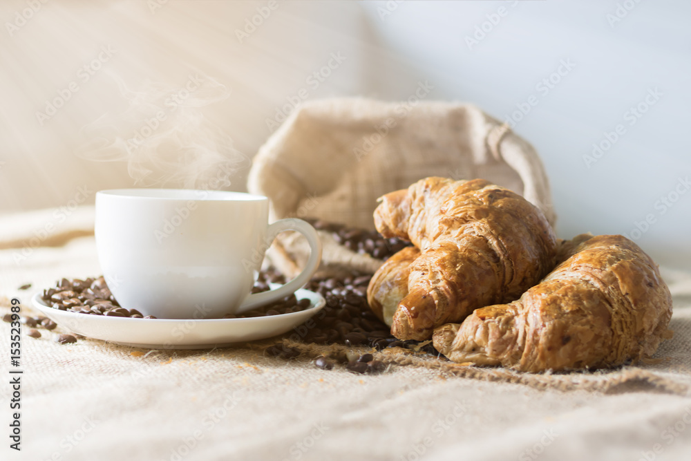 Coffee and Croissant are placed on the table in the morning. Coffee and Croissant are placed on the table in the morning.