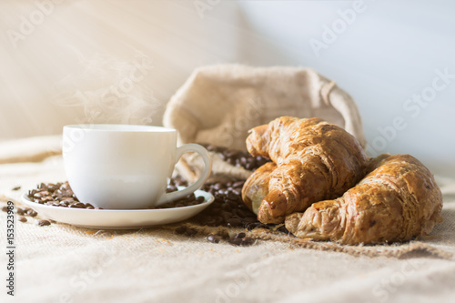 Coffee and Croissant are placed on the table in the morning.