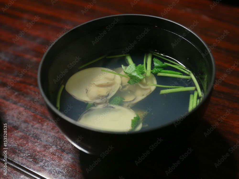 clam clear soup on black bowl with coriander on wooden desk, Japanese food clam clear soup on black bowl with coriander on wooden desk, Japanese food