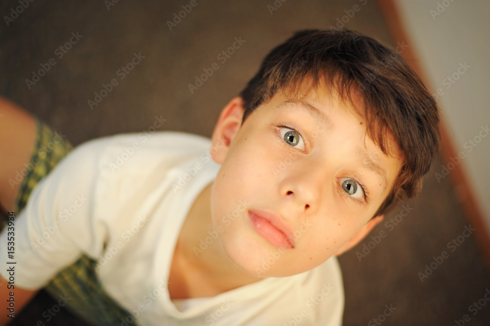 Boy in green shorts and a white shirt sitting and resting. Boy in green shorts and a white shirt sitting and resting.