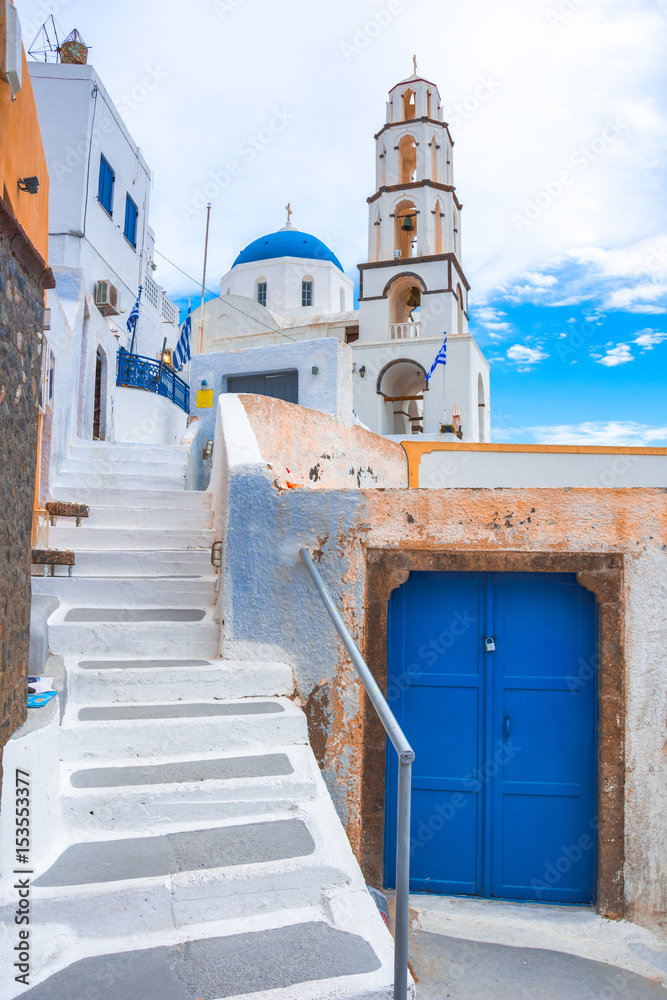 Old colorful wooden doors and bell tower at the traditional village of Pirgos, Santorini, Greece.