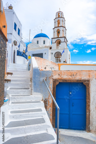 Old colorful wooden doors and bell tower at the traditional village of Pirgos, Santorini, Greece. © gatsi
