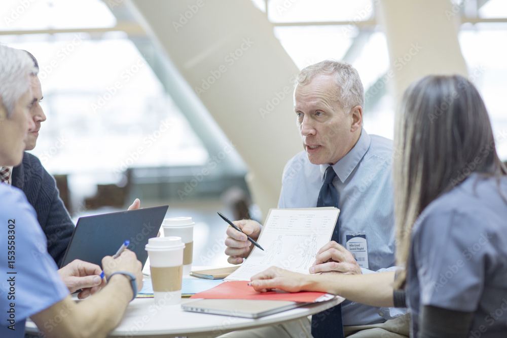 Doctors discussing while sitting in medical room Doctors discussing while sitting in medical room
