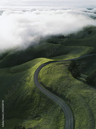 Aerial view of country road amidst landscape against cloudy sky