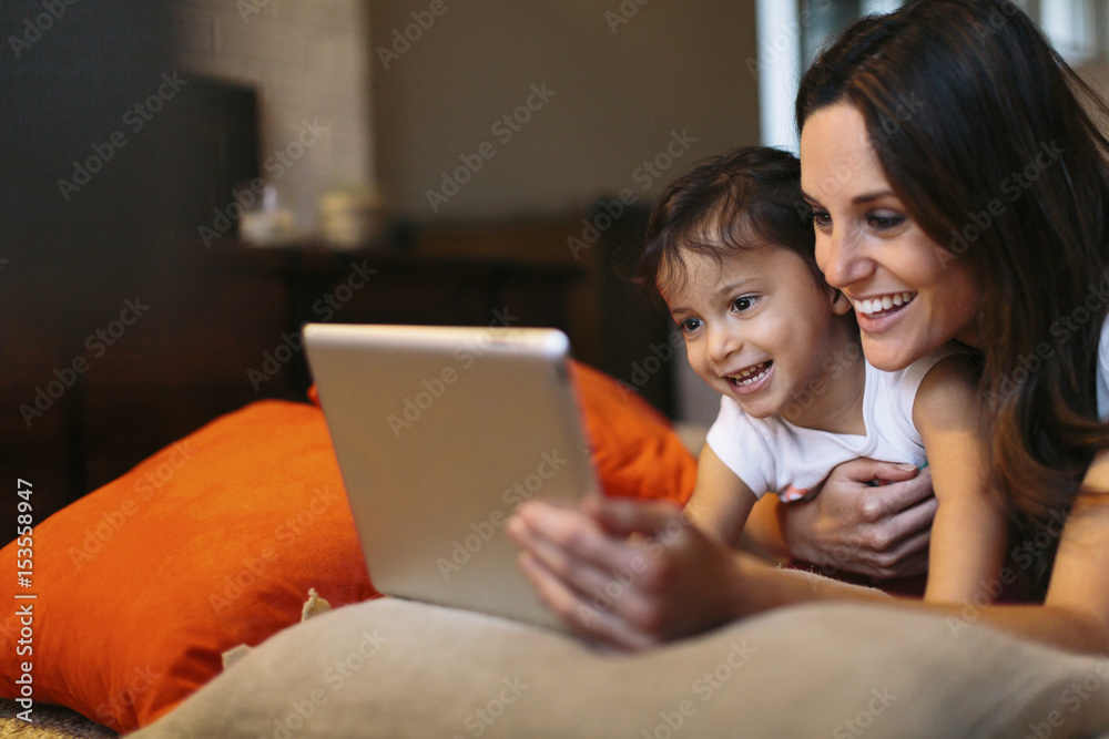 Happy mother with daughter looking at tablet computer Happy mother with daughter looking at tablet computer