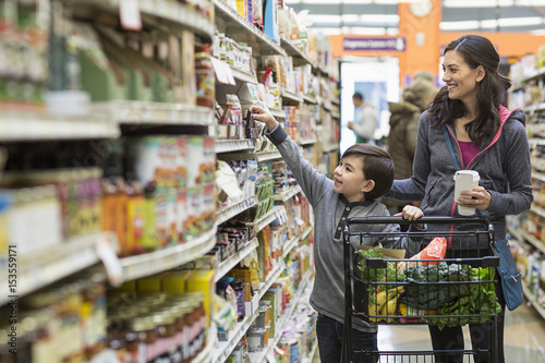 Boy shopping with mother in supermarket photo