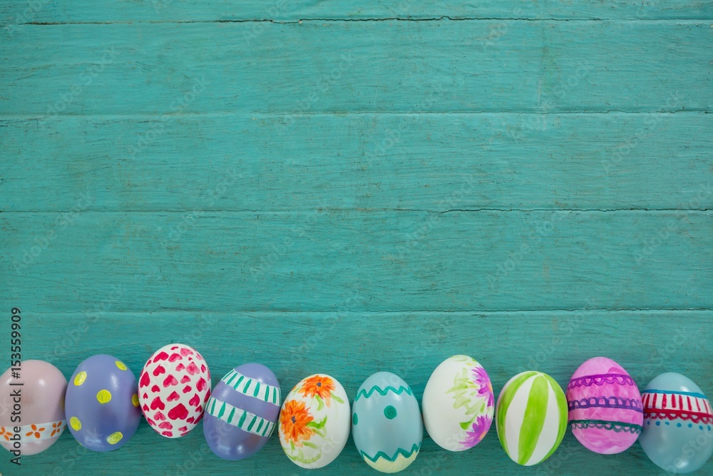 Painted Easter eggs on wooden surface - obrazy, fototapety, plakaty 