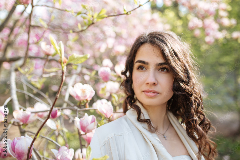 Beauty woman standing on Magnolia blossoming flowers background. Beauty woman standing on Magnolia blossoming flowers background.
