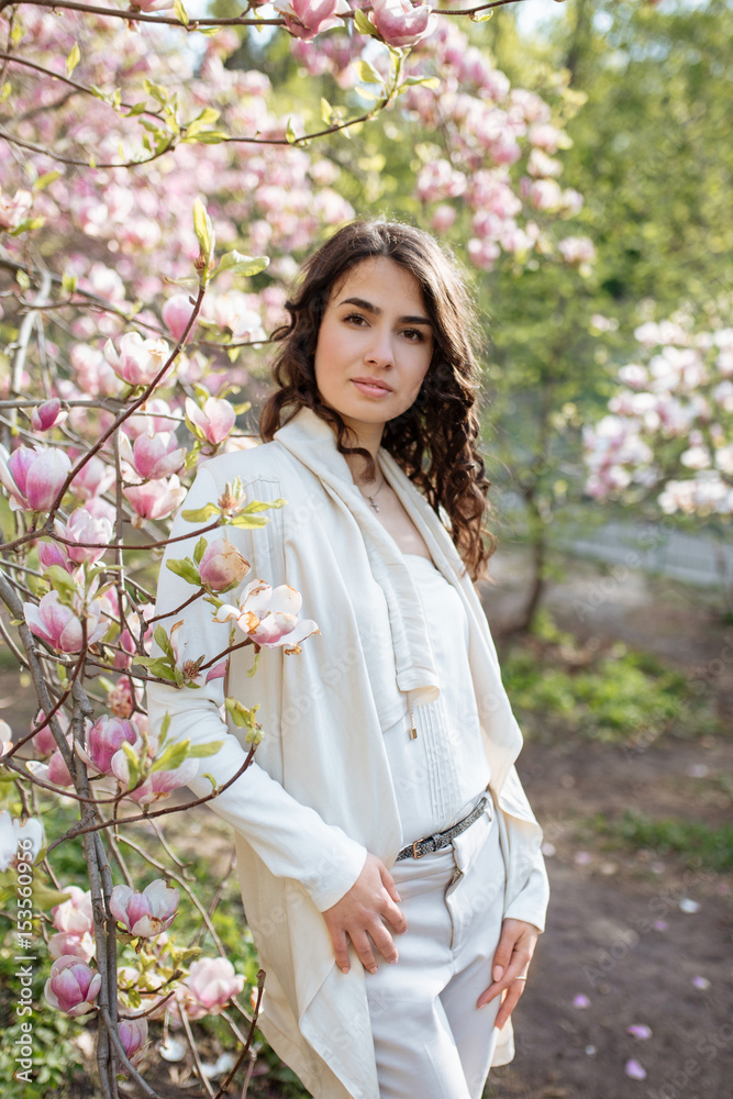 Beauty woman standing on Magnolia blossoming flowers background. Beauty woman standing on Magnolia blossoming flowers background.