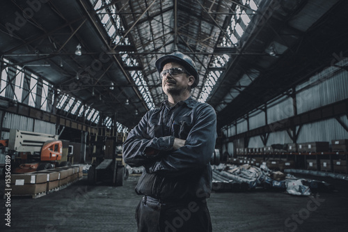 Confident male worker with arms crossed looking away while standing in metal industry