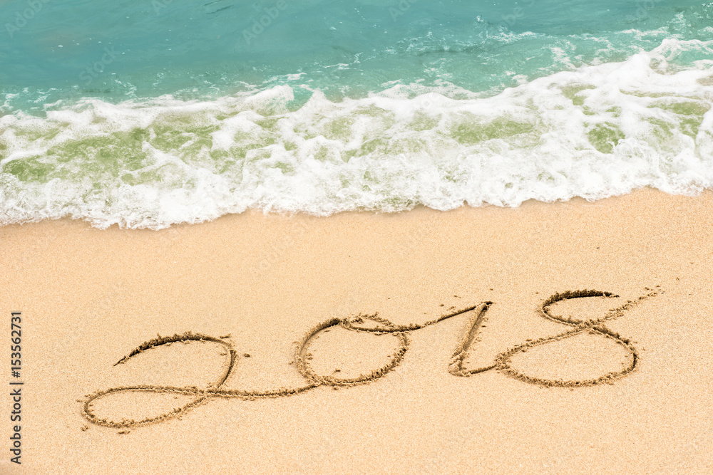 writing 2018 on the beach, happy new year writing 2018 on the beach, happy new year