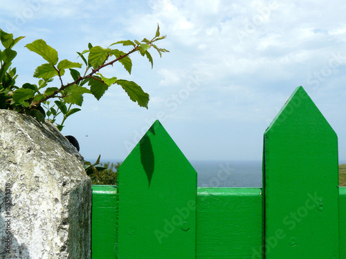 Puerta verde de una valla junto al Cantábrico photo