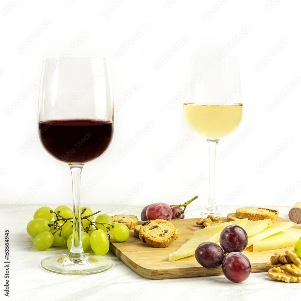 Red and white wine with cheese, bread and grapes