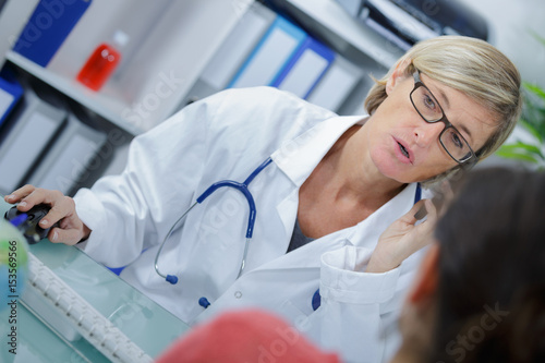 Female doctor in consultation and speaking on the telephone