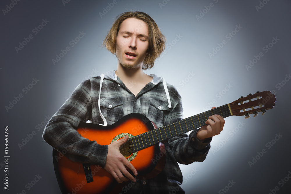Obraz premium Caucasian boy playing on acoustic guitar. Teenager with classic wooden guitar