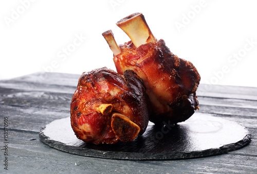 Canvas Print Smoked ham hock with herbs and spices on wooden plate.