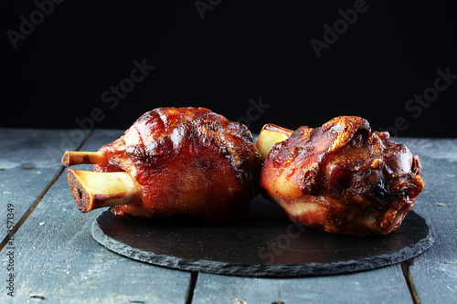 Canvas Print Smoked ham hock with herbs and spices on wooden plate.