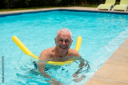 Senior man swimming with inflatable tube