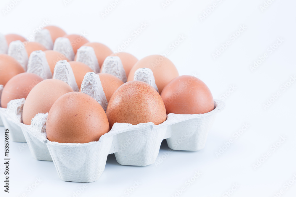 Close up on a large tray of brown eggs isolated on white background