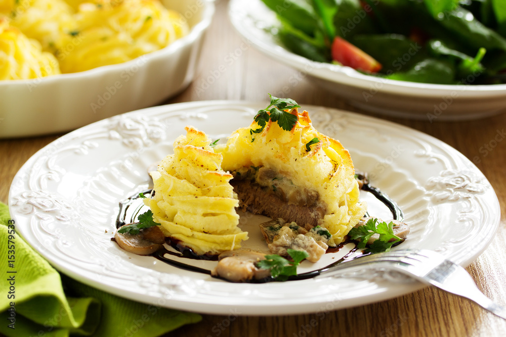 Baked meat with mushrooms in mashed potatoes.