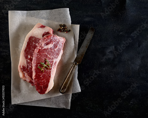 raw beef steak marble on a black background.top view