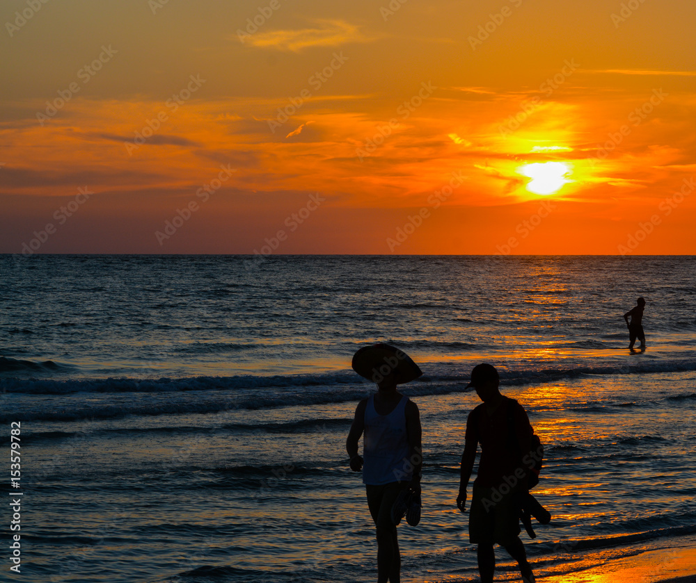 The sunset with the silhouette of people on the beach. This is at Indian Rocks Beach, Gulf of Mexico, Florida.