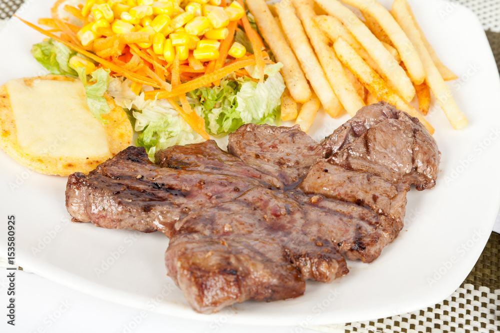 Grilled Meat with French Fries and Salad Grilled Meat with French Fries and Salad