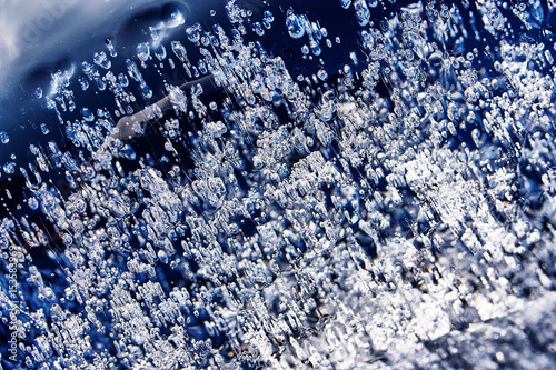 Frozen gas bubbles settle on the air cavity in the ice. A beautiful natural phenomenon. Greenhouse effect. Colorful blue cool colors. Abstract background. Frozen, unique ice bubbles.. photo