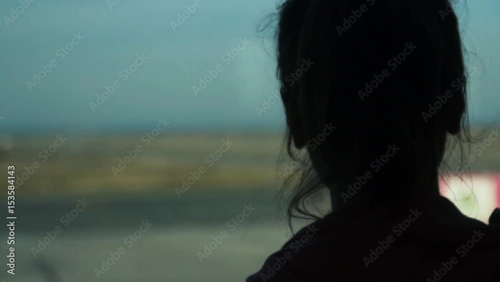 Girl at the airport window looking to the planes Girl at the airport window looking to the planes