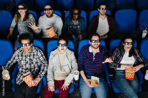 Excited friends watching a movie at 3D cinema