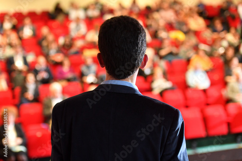 Speaker at a conference in front of auditorium