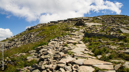 Babia gora mountain in Poland with stones, blue sky with white clouds plants