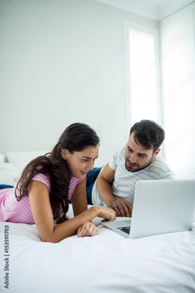Couple using laptop in the bedroom Couple using laptop in the bedroom