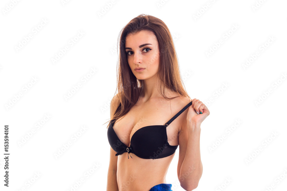 charming young girl with chic chest holds hand bra and looks into