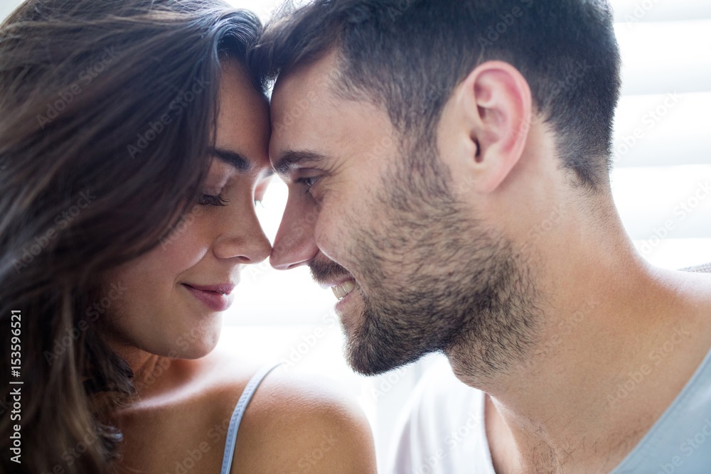 Young couple romancing in bedroom Young couple romancing in bedroom