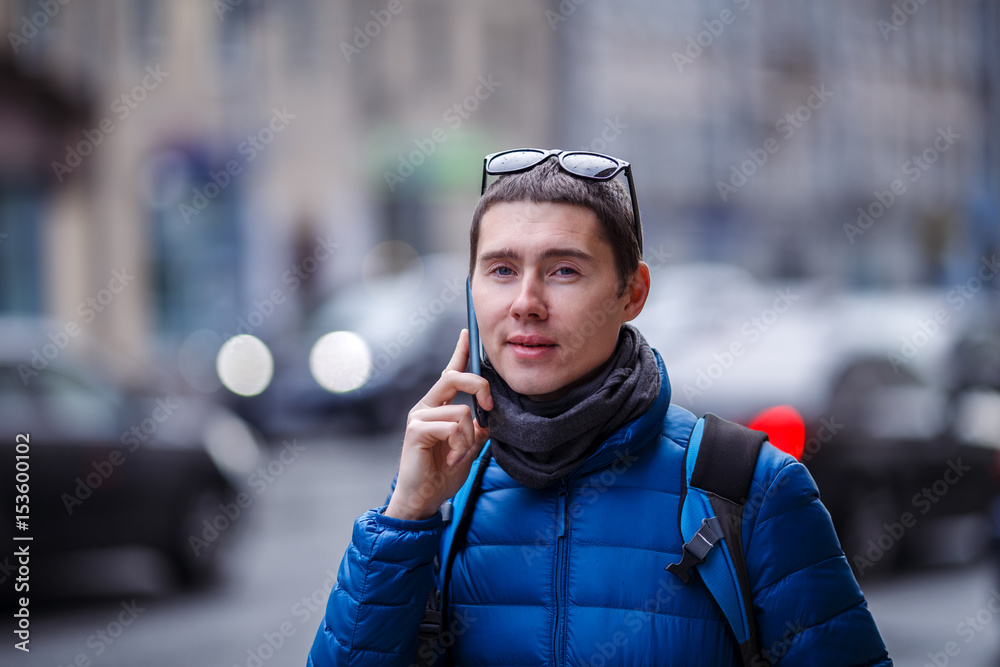 Young man talking on phone, standing on street Young man talking on phone, standing on street