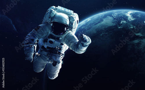Astronaut in front of the Earth planet. Elements of this image furnished by NASA