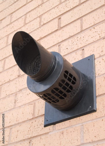 Gas boiler flue outlet on exterior wall of a modern building in the UK.