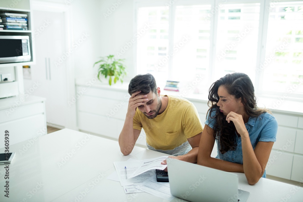 Fototapeta premium Worried couple calculating their invoices