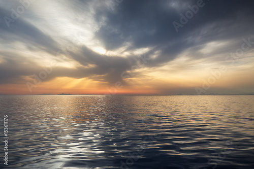 Fantastic sunset over a calm sea. Dramatic reflection of clouds