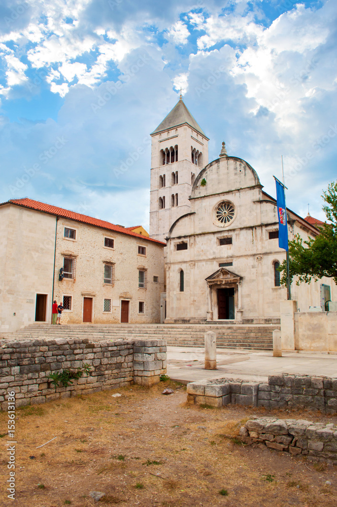 Tower of St. Mary's church, the forum square and stone ruins on a summer morning. Dramatic cloudy sky. Solitary and cozy Zadar center, Croatia
