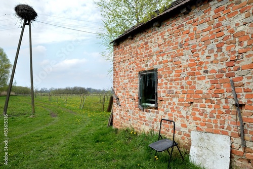 Old rural building in the wilderness and lonely chair