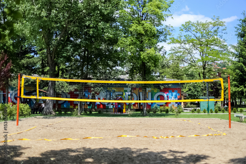 Volleyball court to the network in the middle of the sandy surface, volleyball in the park, sunny day