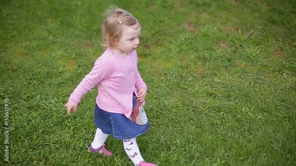 Little two-year-old beautiful blonde girl running through green grass, slow motion video Little two-year-old beautiful blonde girl running through green grass, slow motion video
